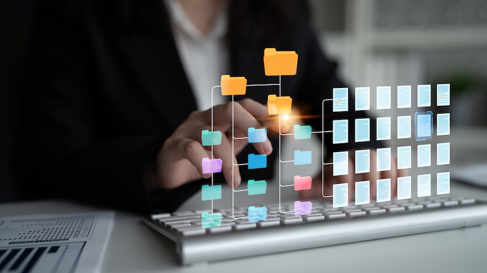 Business professional organizing connected digital folders and documents on a laptop